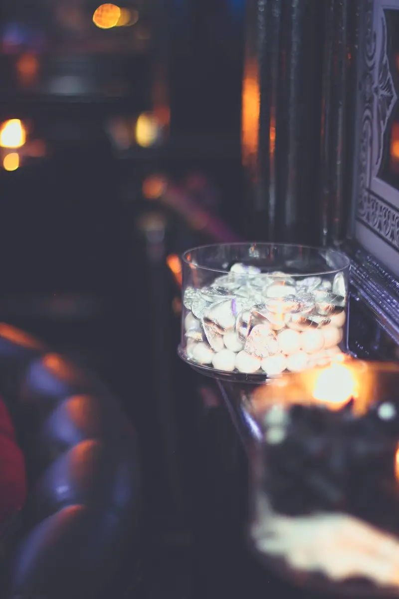 Wrapped favours in a glass vessel, caught in candlelight