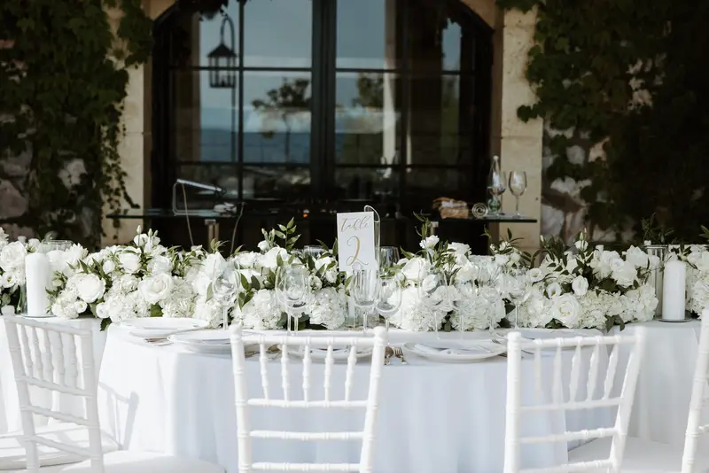 Tables laid for the evening with the sea and the last of the light through the colonnade behind them